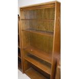 A set of three modern oak open bookcases, two with adjustable shelving,