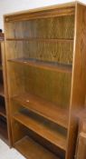 A set of three modern oak open bookcases, two with adjustable shelving,