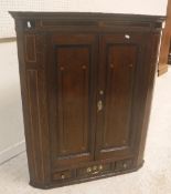 A George III North Country English oak and inlaid hanging corner cupboard,