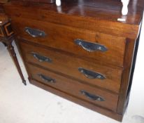 A Lombok teak chest of three drawers with iron handles raised on a plinth base,