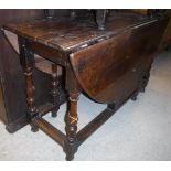 A late 17th Century oak oval gate-leg drop-leaf dining table on baluster turned and ringed supports