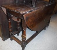 A late 17th Century oak oval gate-leg drop-leaf dining table on baluster turned and ringed supports