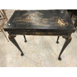 An early 20th Century black lacquered and chinoiserie decorated fold over card table,