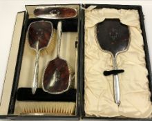 A George V silver and tortoiseshell mounted dressing table brush set comprising mirror,