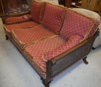 An early 20th Century mahogany framed and double caned Bergère settee with acanthus carved