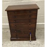 A circa 1900 stained pine collector's chest of six long drawers with turned knob handles,