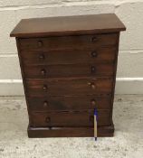 A circa 1900 stained pine collector's chest of six long drawers with turned knob handles,