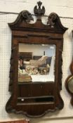 A 20th Century mahogany and gold painted wall mirror in the early Georgian manner with broken arch