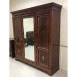 An Edwardian mahogany and satinwood banded and marquetry inlaid triple wardrobe with central