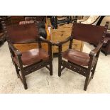 A pair of oak framed throne chairs in the 17th Century Spanish style with studded leather back and