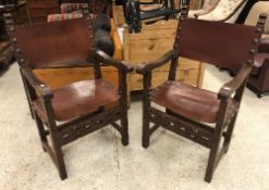 A pair of oak framed throne chairs in the 17th Century Spanish style with studded leather back and