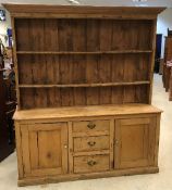 A circa 1900 pine dresser, the two tier boarded plate rack over three central drawers,