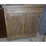 A Continental pine cupboard with single drawer over two cupboard doors enclosing a shelf,