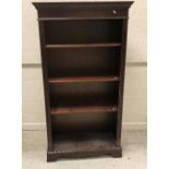 A modern mahogany bookcase with three adjustable shelves.