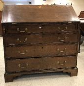 A George III oak bureau, the plain top above a sloping fall with loveheart shaped escutcheon,