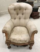 A Victorian button back armchair with carved show frame, raised on carved and fluted front legs,