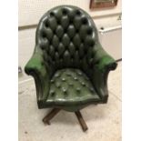 A modern green buttoned leather office scroll arm swivel chair,