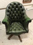 A modern green buttoned leather office scroll arm swivel chair,