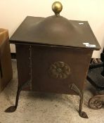 A copper and brass Art Nouveau style coal box with rosette decoration raised on iron pad feet