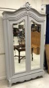 A French painted armoire in the Louis XV taste with two shaped bevel edged mirrored doors