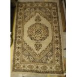 A Turkish rug, the central panel set with circular medallion on a cream ground within a cream,