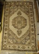 A Turkish rug, the central panel set with circular medallion on a cream ground within a cream,
