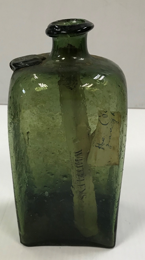 An 18th century four sided green glass bottle with seal to shoulder 18.5 cm high x 9 cm x 7.