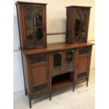 An Edwardian mahogany and blind fretwork decorated side cabinet with two glazed cabinets linked by