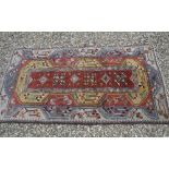 An Helas rug, the central panel set with