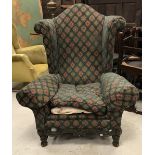 A circa 1900 upholstered wing back scrol