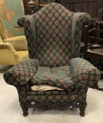 A circa 1900 upholstered wing back scrol