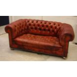A circa 1900 buttoned red leather upholstered chesterfield scroll arm sofa on squat bun feet 163 cm