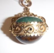 A 9 carat gold mounted pendant set with swivel caboshon cut tiger's eye and jade beads on an