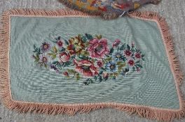 A needlework rug, the green ground set with floral spray within a tasselled edge approx.