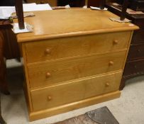 A modern light ash chest of three long drawers on a plinth base,