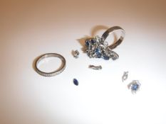 A white metal ring set with blue coloured stones,