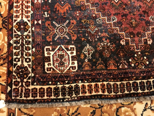 A Persian rug with centre lozenge medallion on a red ground, - Image 3 of 17