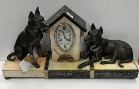 A 1930s marble and onyx cased clock garniture as a dog kennel flanked by two hounds, one seated,