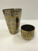 An Indian silvered brass and engraved goblet with Sanskrit decoration, 11 cm high,