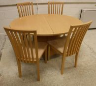 A Skovby pale beech oval extending dining table on oval centre pedestal,