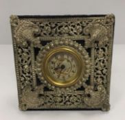 A Victorian mantel clock with pierced plated decoration enclosing the dial with fairy and dragonfly