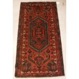 A modern Persian rug, the central panel set with lozenge shaped medallion on a red ground,