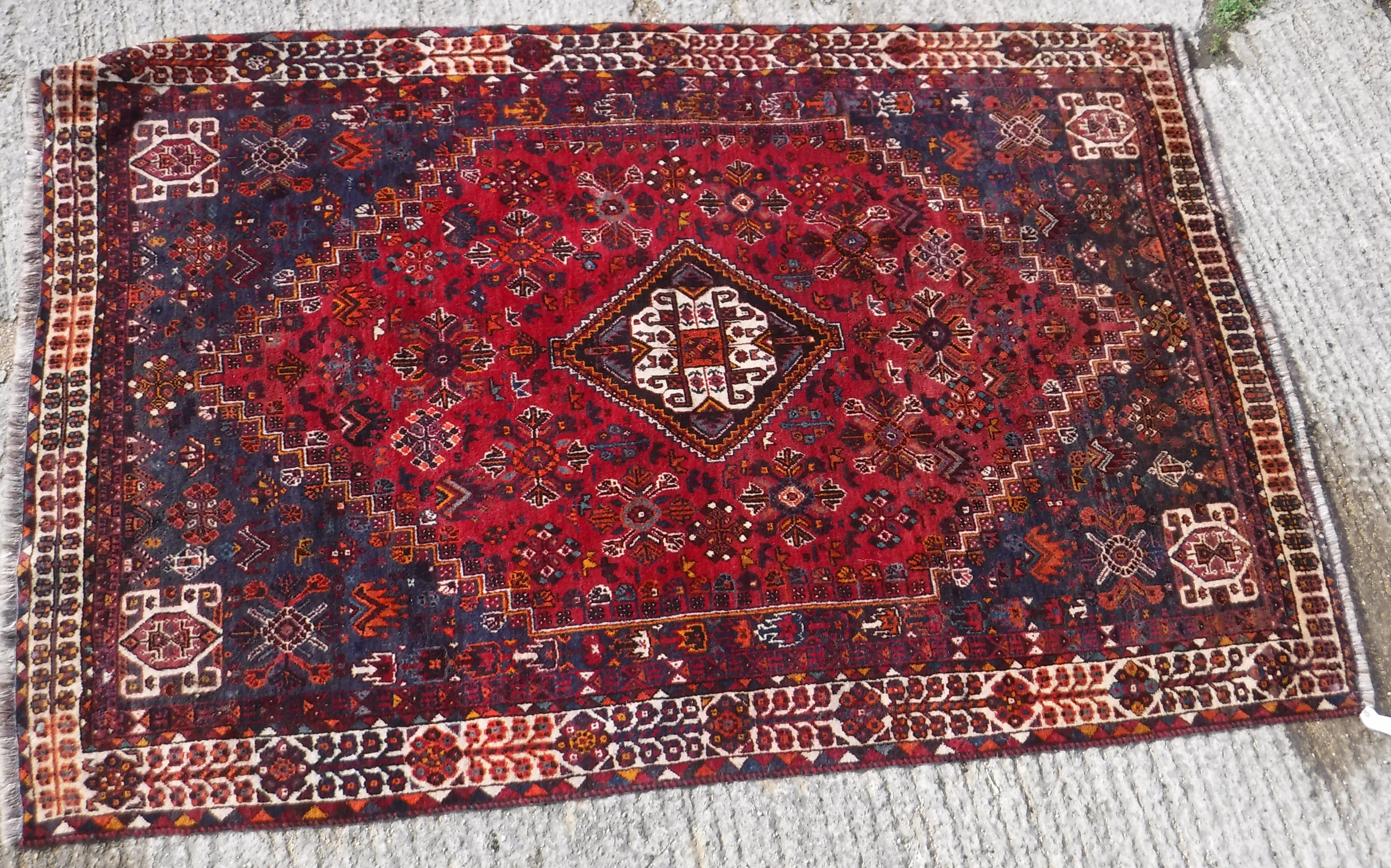 A Persian rug with centre lozenge medallion on a red ground, - Image 2 of 17