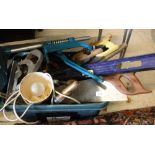 A box containing various tools including saws, level, Coopers electric lawn edger, spades, forks,