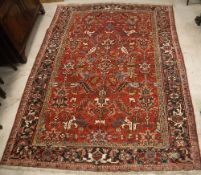A Heriz carpet, the central panel set with all-over stylised foliate decoration on a red ground,