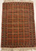 A Turkamen rug, the central panel set with repeating tiled decoration on a red ground,