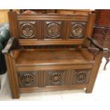 An oak box seat hall settle in the 17th Century style with spindle turned roundel decoration on