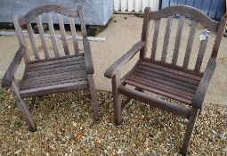 Two modern teak slatted wooden garden armchairs