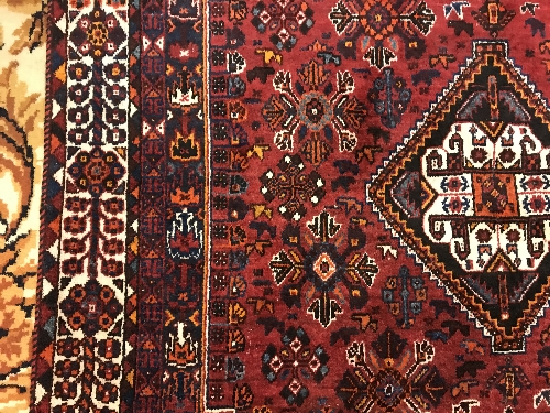 A Persian rug with centre lozenge medallion on a red ground, - Image 7 of 17