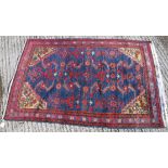 A Caucasian rug, the central panel set with stylised floral decoration on a blue ground,